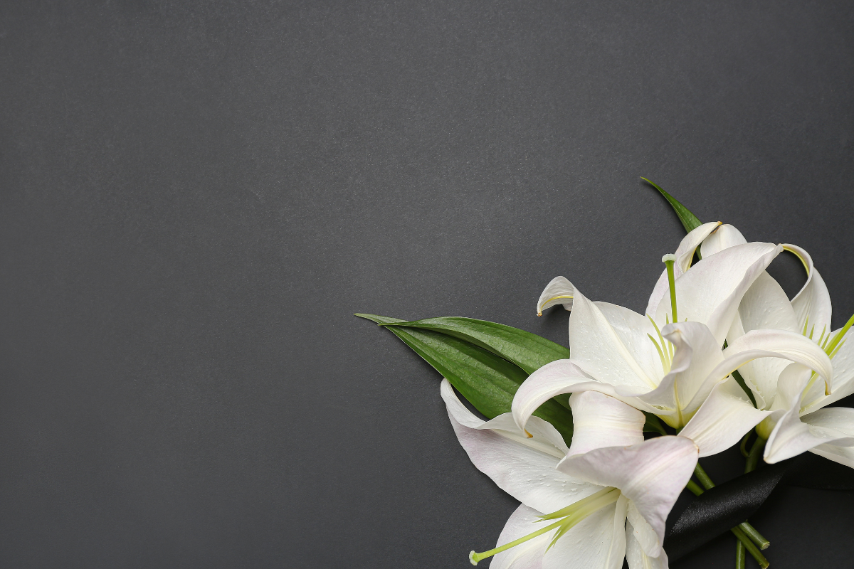 Image of a bouquet and a black mourning band on a gray background.