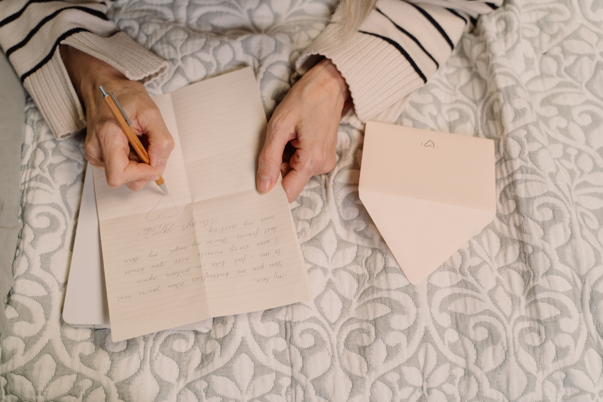 Image of a woman writing a letter of condolence for a blog post covering writing a message of condolence.