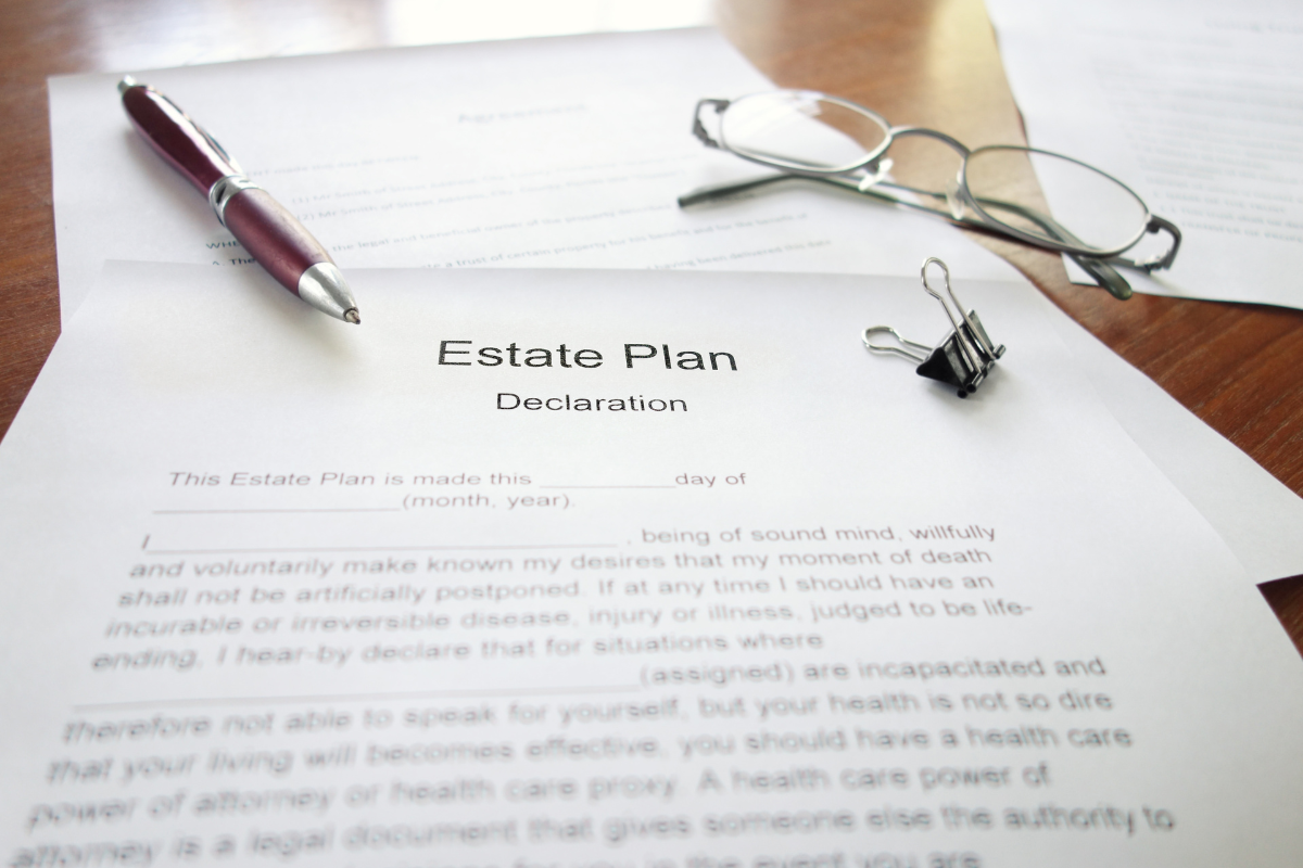 Image of an estate planning declaration template, a pen and a pair of glasses sitting on a desktop.