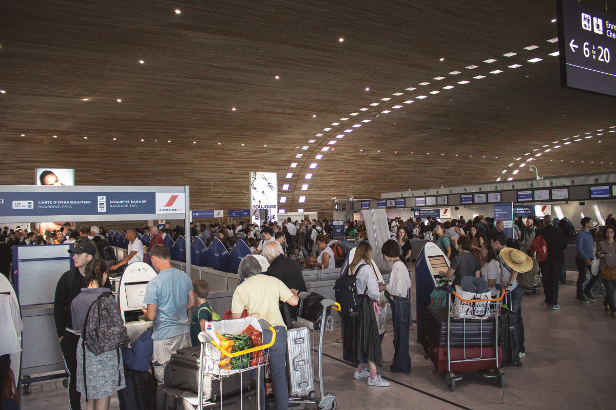 Image of a crowd of people checking in for their flights at an airport.