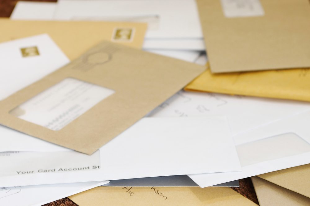 Image of a stack of bills for a blog post answering the question, "what is the Deceased Do Not Contact list, or DDNC list?" 
