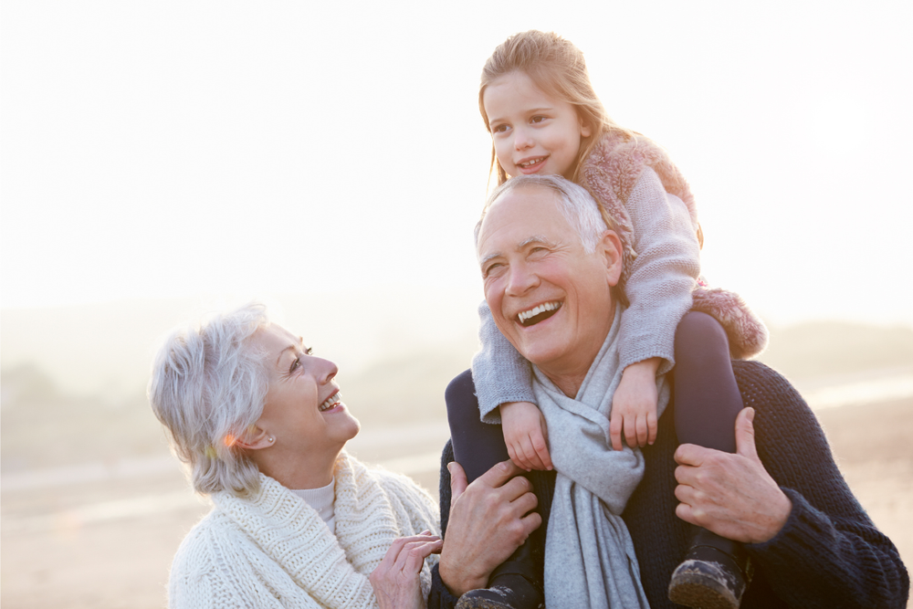 Image of granparents and their granddaughter walking on the beach for a blog post welcoming readers to the Up & Doing Blog