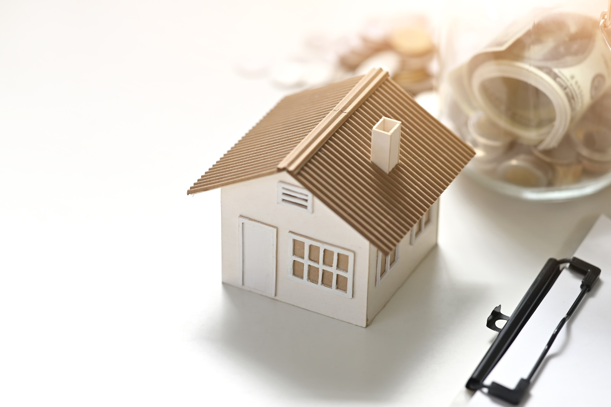 Image of a model house and money on a plate for a blog post covering how to conduct an estate asset inventory.
