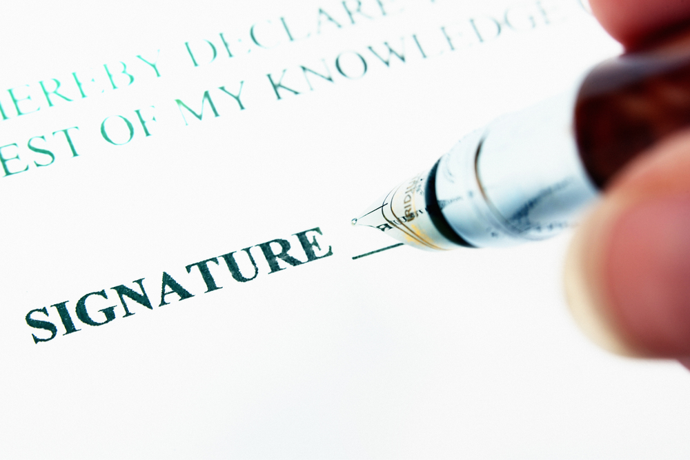 Image of a family member signing a small estate affidavit in front of a notary.