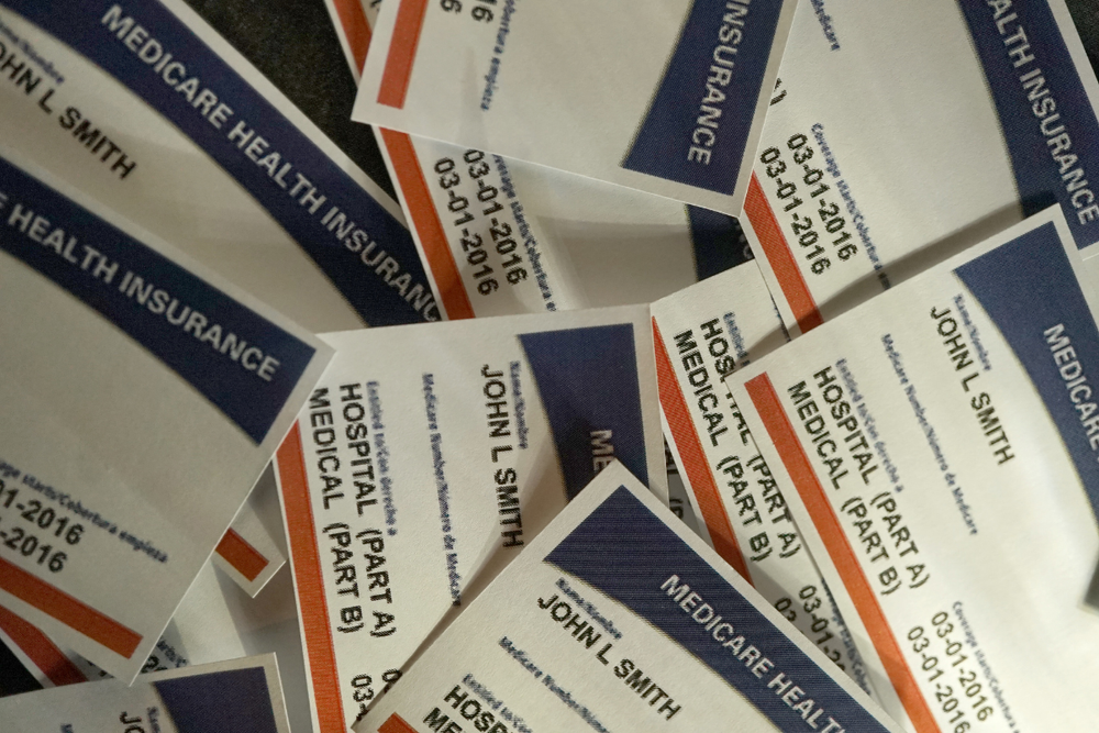 Image of a stack of Medicare identification cards for a blog post covering Medicare benefits after death.
