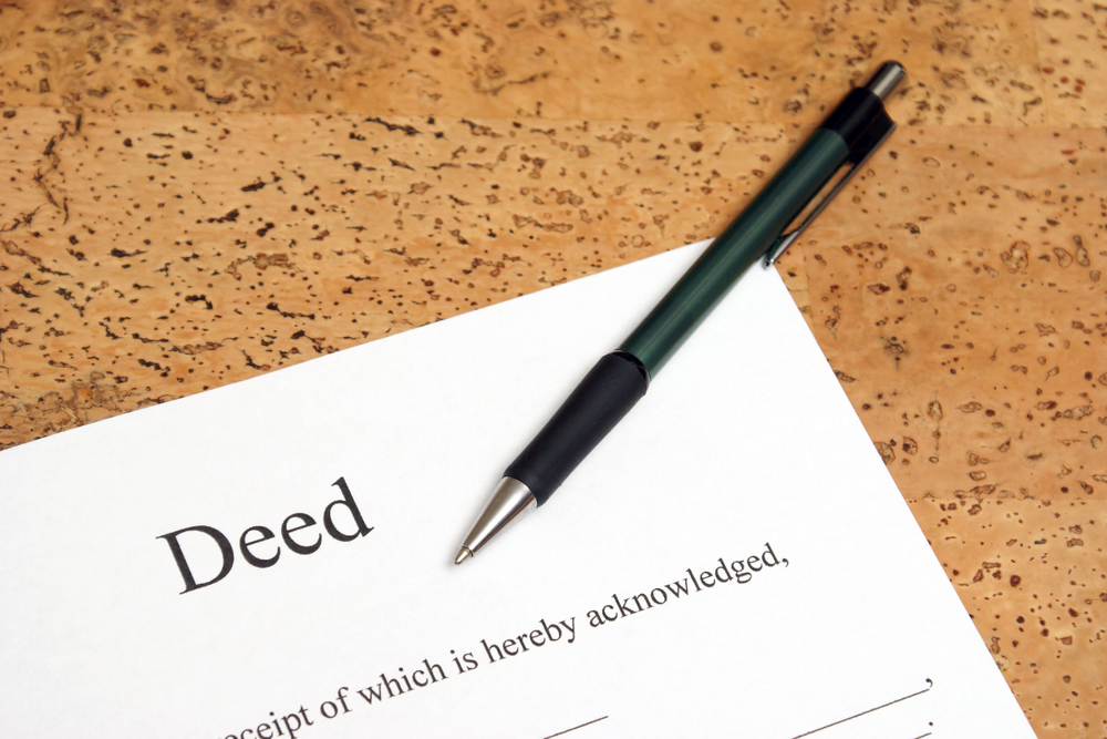 Image of a real estate deed on a desktop for a blog post answering the question, "what is a transfer on death deed?"