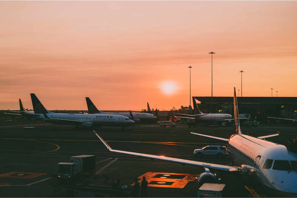 Image of an airliners outside the terminal at dawn for an article covering how to get a bereavement flight fare.